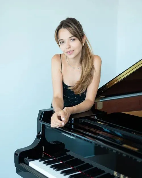 Ana Bursac leaning on a grand piano